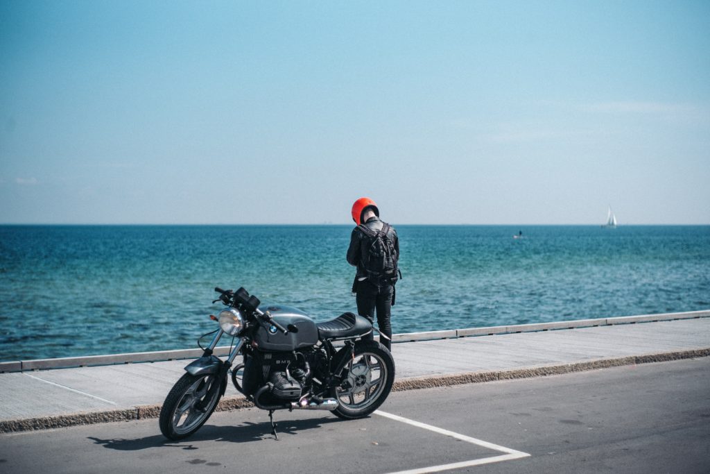 Motorcyclist wearing a red helmet facing Newport Beach Motorcycle Accident Lawyer