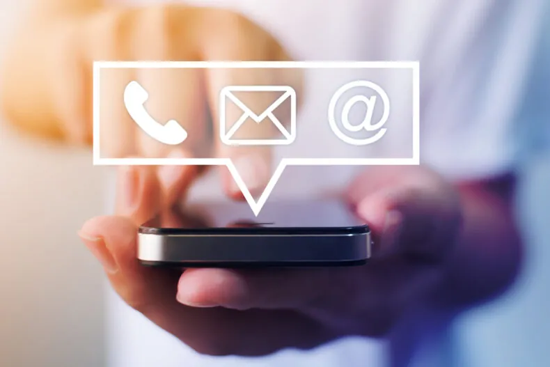 Close-up image of male hands using smartphone with icon telephone email mobile phone and address.