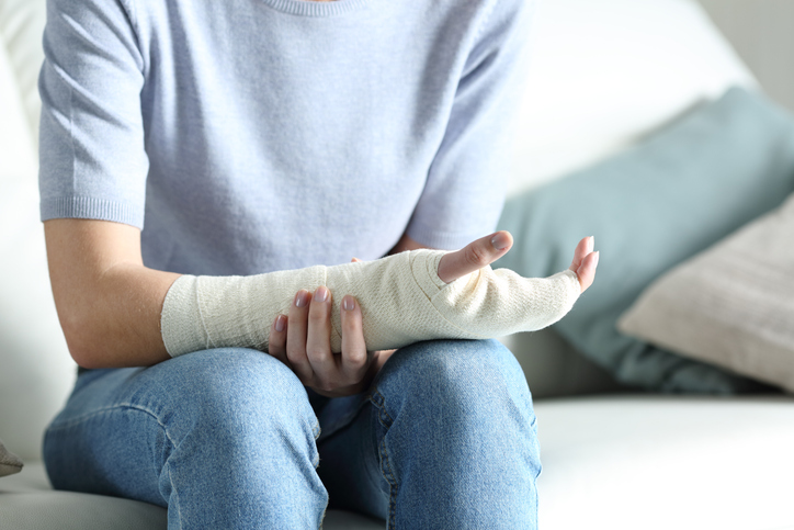 person grabbing their bandaged arm