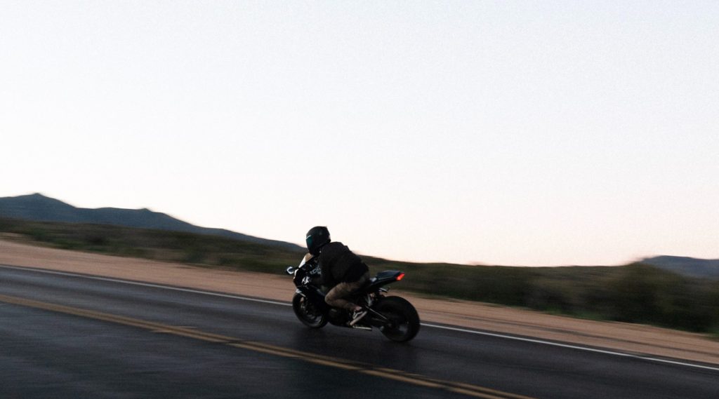Motorcyclist riding a black motorcycle in Orange County.