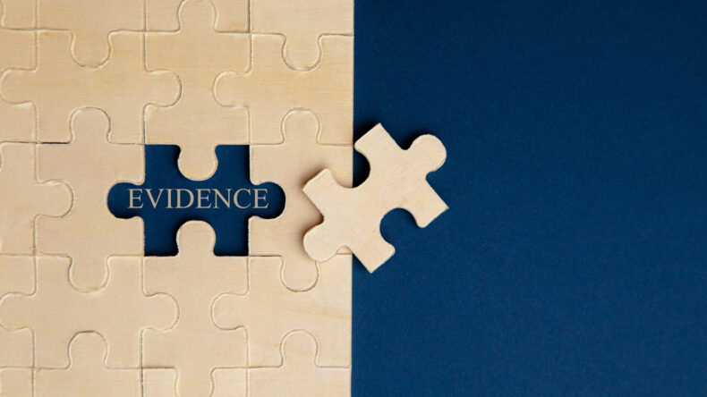 Paper puzzles on a red background to represent negligence is proven with the right evidence