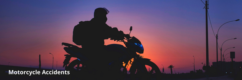 dark figure of a motorcyclist parked in Long Beach with the sun setting in the background 