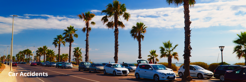 traffic in Long Beach, CA along the side of the beach with a row of palm trees on sunny day with blue skies