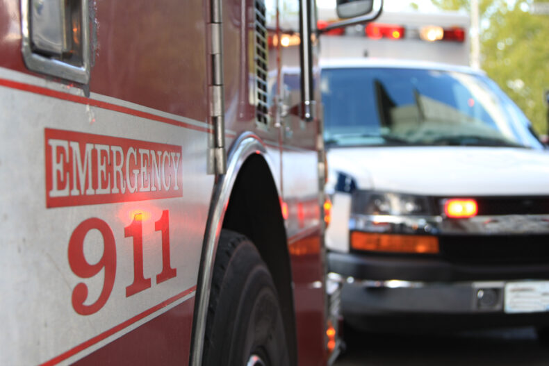 closeup of red firetruck door with 911 printed on the door 