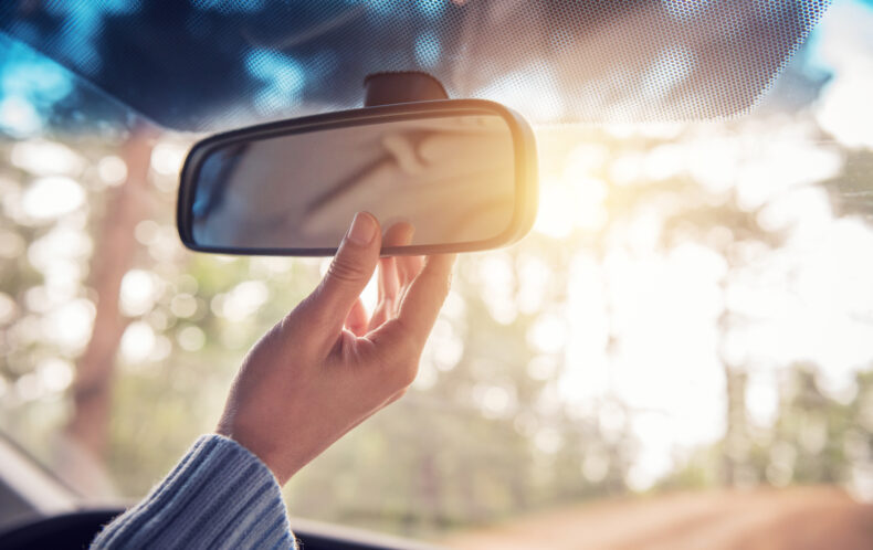 Adjust rear view mirror. Safe driving tips for new drivers.