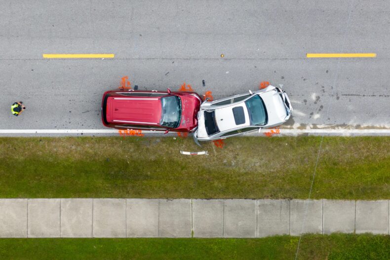 Wide shot of multiple vehicle crash scene at urban intersection
